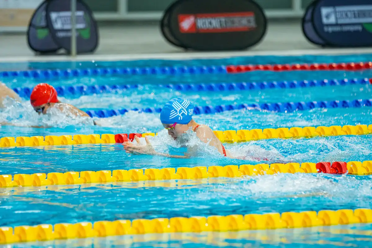 Junior age-group swimmer racing in a pool lane